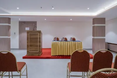 a conference room with chairs and a podium in the middle at Hotel Golden Couch in Badagara