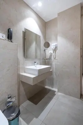 a bathroom with a sink and a mirror at Hotel Golden Couch in Badagara