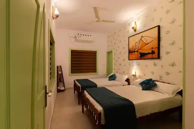 a bedroom with two beds and a painting on the wall at GEE DE Homes in Kizhake Chālakudi