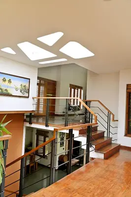 a spiral staircase in a room with wooden floors at Midtown Meadow in Kozhikode