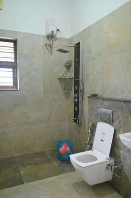 a bathroom with a toilet and a sink at Midtown Meadow in Kozhikode