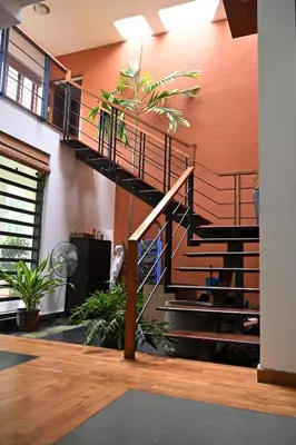 a spiral staircase in a room with plants at Midtown Meadow in Kozhikode