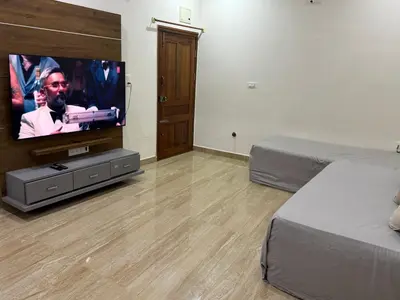 a bedroom with a flat screen tv and a bed at LUXE Premium Service Appartment in Mysore