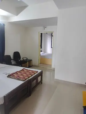 a bedroom with a bed and a room with a bed sidx sidx sidx at Ambadi Blueberry in Guruvāyūr