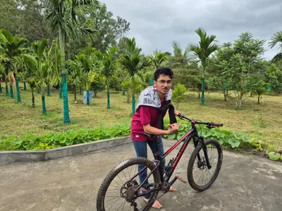 a man riding a bike in a park at Mountain View Stay in Kushālnagar