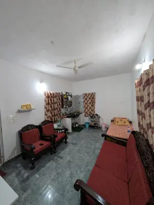 a living room with red chairs and a couch at Mountain View Stay in Kushālnagar