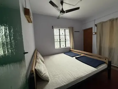 a bed in a room with a window at JMS Holiday homes in Coonoor