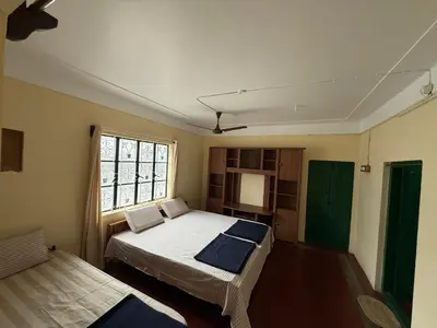 a bedroom with two beds and a window at JMS Holiday homes in Coonoor