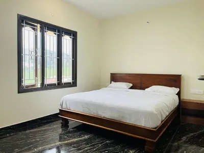a bedroom with a large bed and two windows at Away From Home - 8 - HomeStay, Entire 2 BHK Villa in Ooty