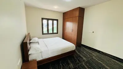 a bedroom with a white bed and a window at Away From Home - 9 - HomeStay, Entire 2 BHK Villa in Ooty