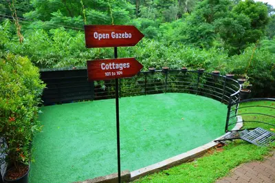 a sign that says open garden with a bench at Swiss Holidays in Pinangode