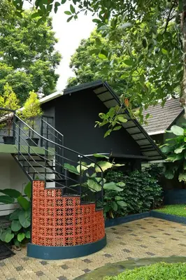 a house with a spiral staircase in a yard at Swiss Holidays in Pinangode