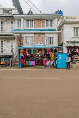 a store on the side of a street with a building at A Ooty Garden Residency in Ooty