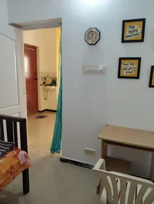 a room with a table and a clock on a wall at A Cozy Homestay in Coimbatore in Coimbatore