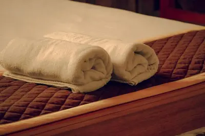 a white towel sitting on top of a bed at Wood Clusters in Suntikoppa