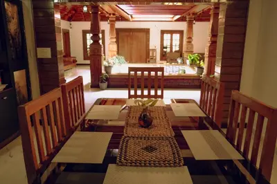 a dining room with a table and chairs at Wood Clusters in Suntikoppa