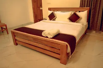 a bedroom with a large bed with two towels on it at Wood Clusters in Suntikoppa
