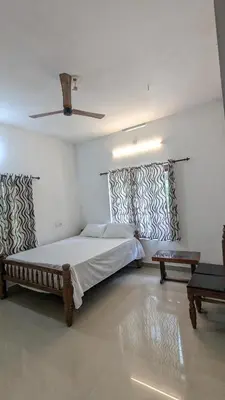 a bedroom with a large bed and a ceiling at Lush Lagoon Homestay in Ambalavayal