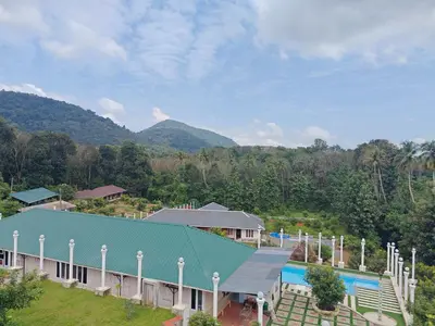 an overhead view of a resort with a swimming pool at AppleLand City Athirapilly by Hotels Cart in Athirappally