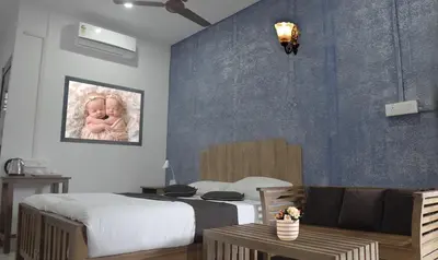 a bedroom with a bed with a baby picture on the wall at AppleLand City Athirapilly by Hotels Cart in Athirappally