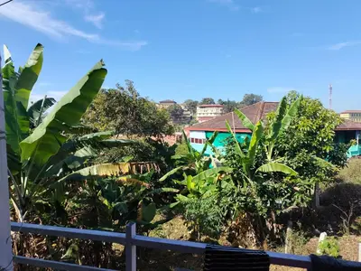 a view of a village with trees and houses at Laali Penthouse in Madikeri