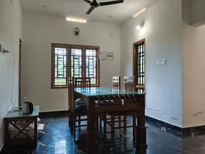 a dining room with a glass table and chairs at Palm view 2 in Kanthalloor