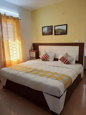 a bedroom with a large bed with two pillows at Hill Grove By Brown Tree Resorts in Ooty