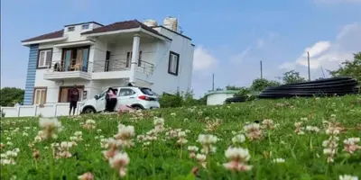 a white car parked in front of a house at Hill Grove By Brown Tree Resorts in Ooty