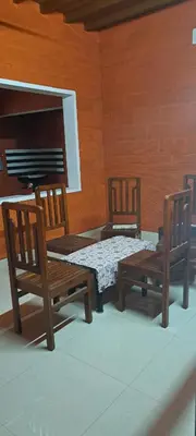 two wooden chairs and a bed in a room at Kadavath Homestay in Ernakulam