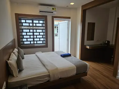 a bedroom with a large bed with a window at SUROOR Recidency in Virajpet