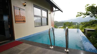 a swimming pool in front of a house at Manjoora Saddles Resorts & Spa in Padinjarathara