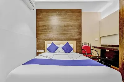 a bedroom with a large bed with blue pillows at Hotel Karpagam Lodging House Nr Railway Station & Gandhipuram bus stand in Coimbatore