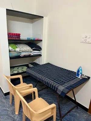 a table and two chairs in a room at Athithi AC Studio Flat By Shivalaya Stays in Podanūr