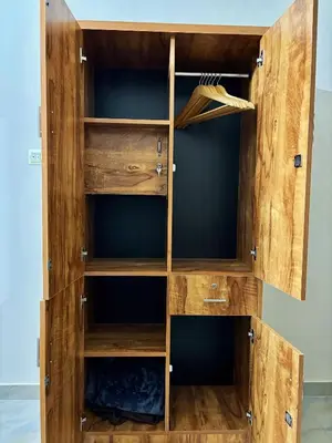 a wooden closet with wooden shelves and doors at Saraa Homes Fully Furnished 2BHK Apartment in Kulattūr