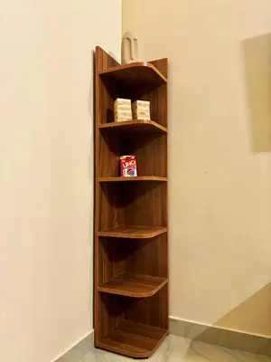 a wooden book shelf against a wall at Saraa Homes Fully Furnished 2BHK Apartment in Kulattūr