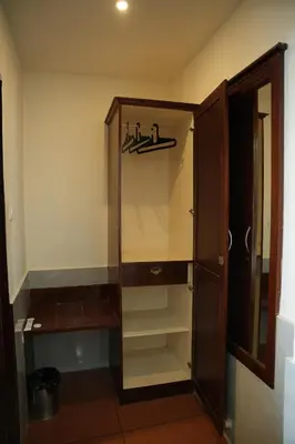 a closet with a glass door and shelves in a room at Shola Heaven Resort in Kanthalloor