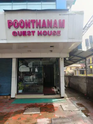 a store with a sign for a postman guest house at Poonthanam guest house in Guruvāyūr