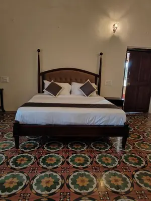 a large bed in a room with a rug at The Estate Bay by Z Vacations in Gonikoppal