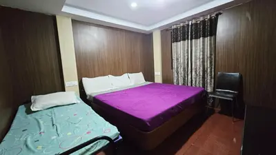 a small bedroom with a purple bed and a chair at Mananya Cottage Ooty in Ooty