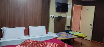 a bedroom with a bed and a tv on the wall at Mananya Cottage Ooty in Ooty