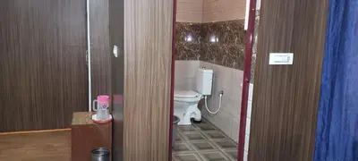 a bathroom with a white toilet in a room at Mananya Cottage Ooty in Ooty