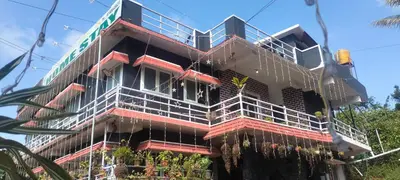 a building with scaffolding on the side of it at Laharya couple room in Madikeri