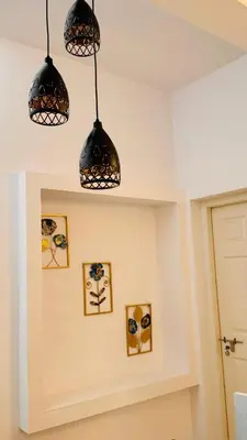 a room with three lights hanging from the ceiling at Niel Valley Homestay - Poomala in Mulagunnathukāvu