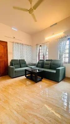 a living room with two green couches and a table at Niel Valley Homestay - Poomala in Mulagunnathukāvu