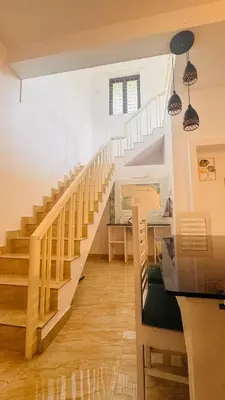 a staircase in a living room with a table and chairs at Niel Valley Homestay - Poomala in Mulagunnathukāvu