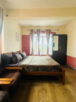 a bedroom with a large bed and a couch at Green Hill in Coonoor