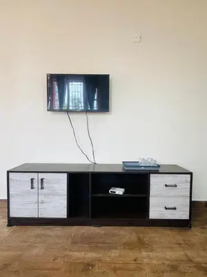 a flat screen tv sitting on top of a entertainment center at Green Hill in Coonoor