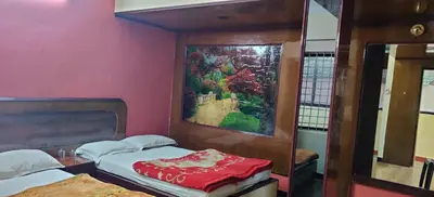 a room with two beds and a painting on the wall at Hotelsapphire in Ooty
