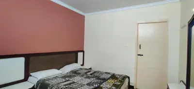a bedroom with a bed and a red wall at Hotelsapphire in Ooty
