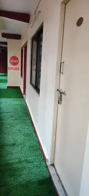 a corridor with a door and a green carpet at Hotelsapphire in Ooty